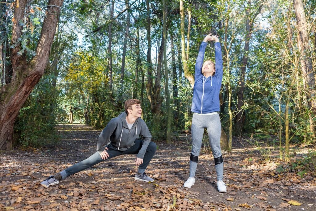 Friends sportswear doing stretches sunny day