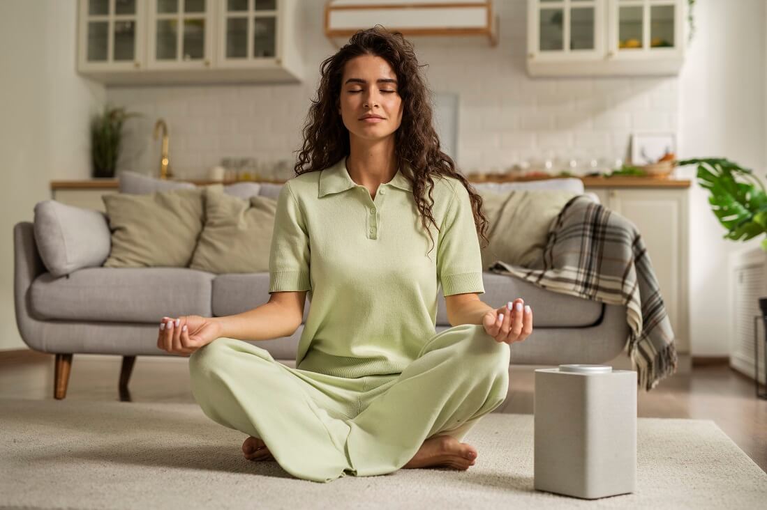 full shot woman meditating home (1)