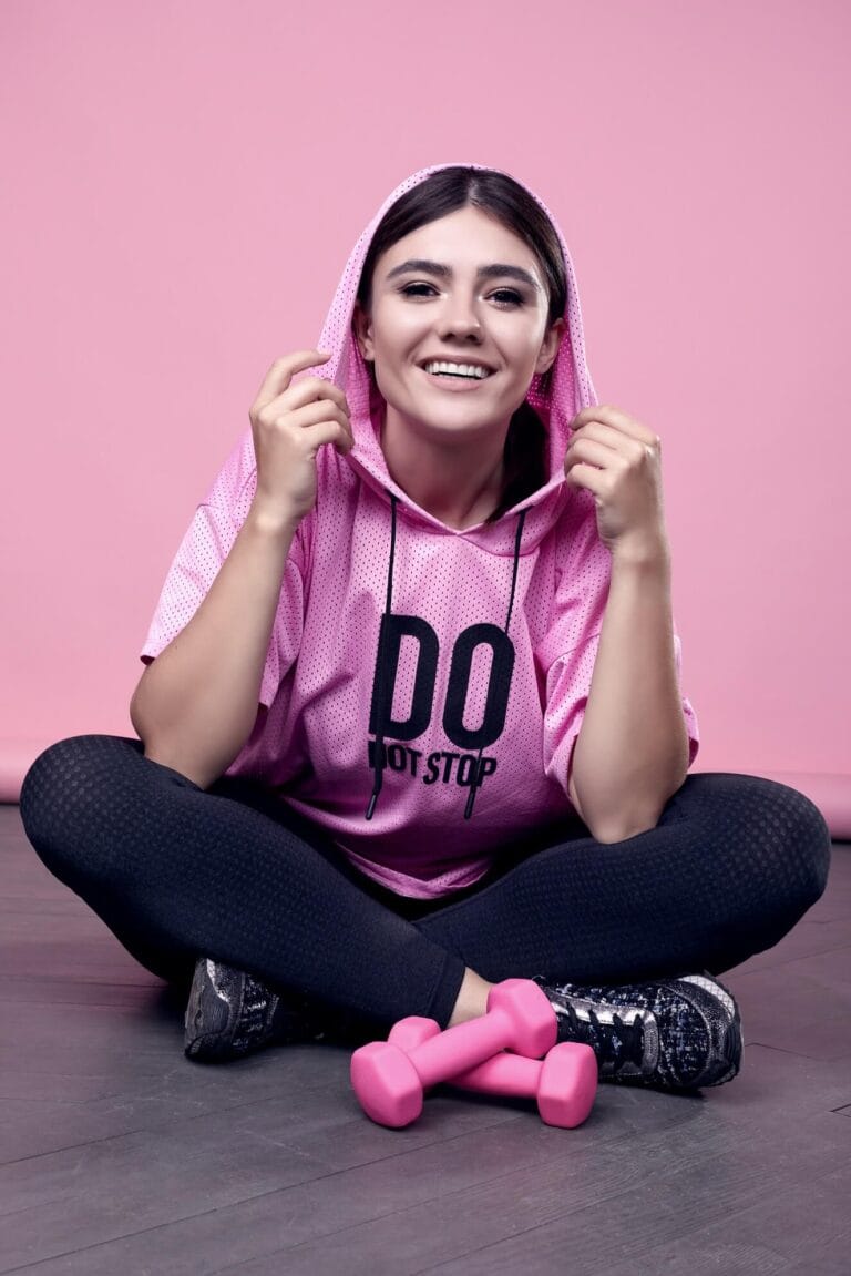 portrait gorgeous body positive latin woman pink sports hoodie exercising with dumbbells pink (1)