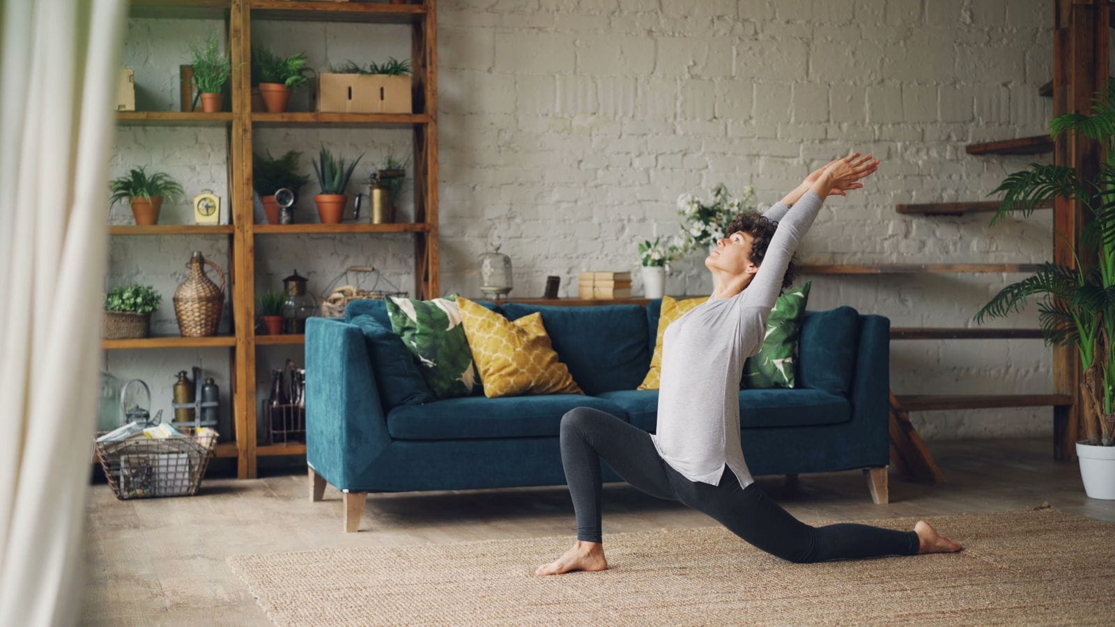 Person doing a yoga lunge stretch at home as part of a cool-down routine after a workout